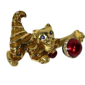Gold-tone cat with heart collar holding a red rhinestone ball brooch/pin.